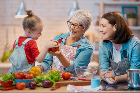 Healthy food at home. Happy family in the kitchen. Grandma, mother and child daughter are preparing...