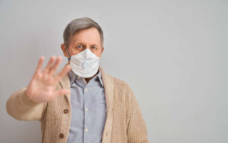 Old man wearing facemask during coronavirus and flu outbreak. Virus and illness protection, home quarantine. COVID-2019の写真素材
