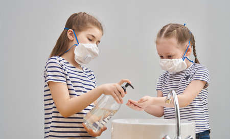 Girls are wearing face masks and washing their hands during coronavirus and flu outbreak. Virus and...