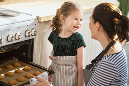 Happy loving family are preparing bakery together. Mother and child daughter girl are cooking...