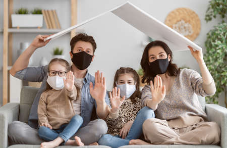 Family is wearing facemasks during coronavirus and flu outbreak. Virus and illness protection, quarantine. COVID-2019. A call to stay at homeの写真素材