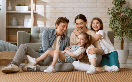 Happy family! Two children daughters with mother and father. Mum, dad and girls laughing and hugging. の写真素材