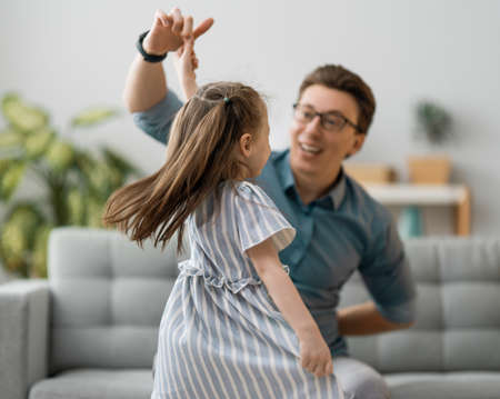 Happy father's day! Dad and his daughter child girl are dancing. Family holiday and togetherness.の写真素材