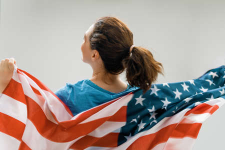 Patriotic holiday. Happy young woman with American flag. USA celebrate 4th of July.