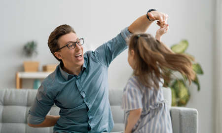 Happy father's day! Dad and his daughter child girl are dancing. Family holiday and togetherness.の写真素材
