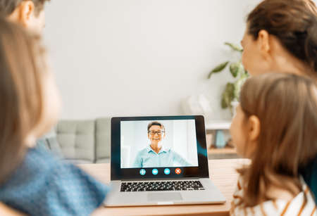 Happy loving family. Father, mother and daughters girls using laptop pc for remote conversation with...