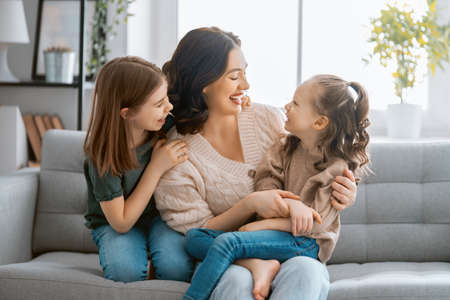 Happy day! Mom and her daughters children girls are playing, smiling and hugging. Family holiday and togetherness. の写真素材