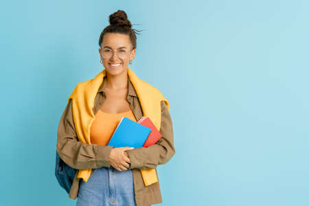 Happy emotional young woman posing and laughing on bright blue background