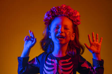 Happy Halloween! Cute little witch at party in colorful lighting.の写真素材