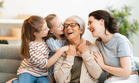 A nice girls, their mother and grandmother enjoying spending time together at home.の写真素材