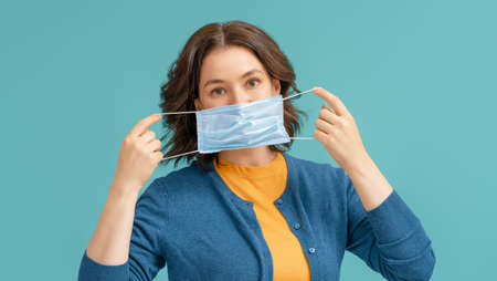 Young woman wearing facemask during coronavirus and flu outbreak. Virus and illness protection, home...