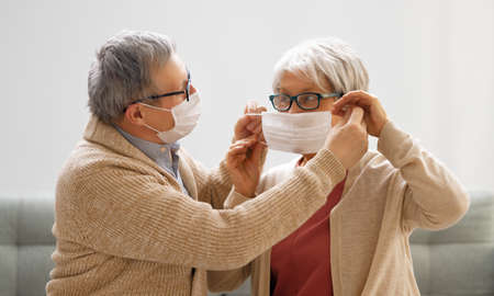 Senior couple wearing facemasks during coronavirus and flu outbreak. Virus and illness protection,...
