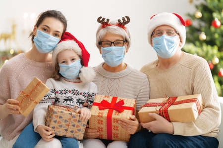 Merry Christmas and Happy Holidays! Grandma, grandpa, mum and children exchanging gifts. Parents and...