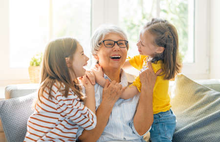 Nice girls and their grandmother enjoying sunny morning. Good time at home.