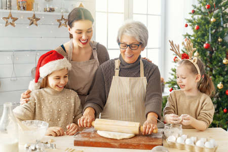 Merry Christmas and Happy Holidays. Family preparation holiday food. Grandma, mother and daughters...