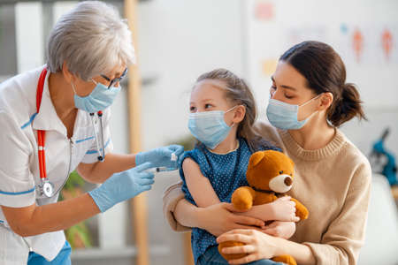 Doctor vaccinating child, kid with mother at hospital.の写真素材