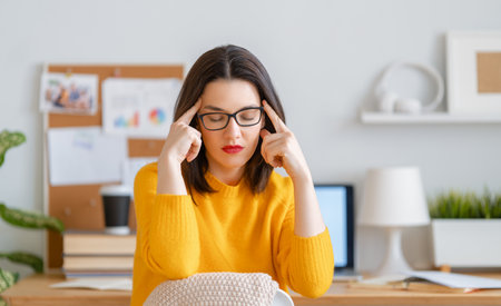 Young businesswoman studying online, watching webinar, podcast on laptop and having a head ache....