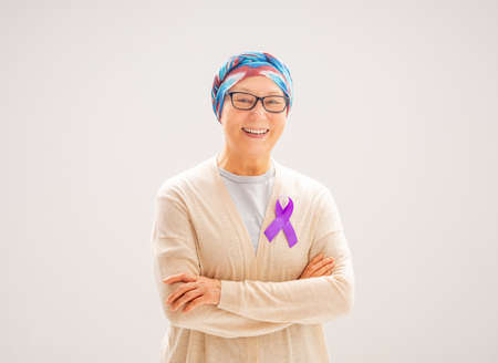 February 4 World Cancer Day. Female patient on grey wall background. Raising knowledge on people living with tumor illness.の写真素材