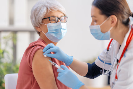 Doctor vaccinating a senior woman. Virus protection. COVID-2019.の写真素材