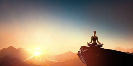 Woman practicing yoga and meditates on the mountain.の写真素材
