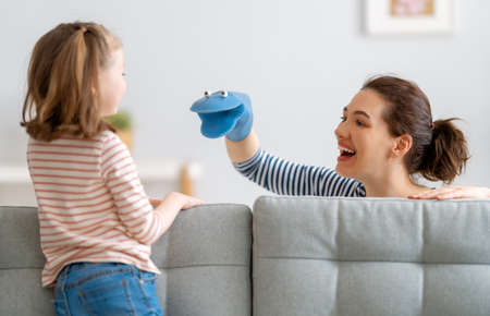 Mom and her daughter child girl are playing and smiling. Family holiday and togetherness.の写真素材