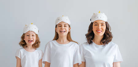 Happy mother's day! Daughters and mother is smiling standing on light grey background. Family togetherness.の写真素材