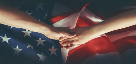 Patriotic holidays. The USA are celebrating 4th of July or Memorial Day. American flag and hands close up.の写真素材