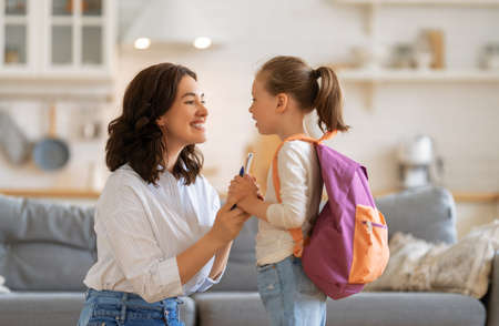 Happy family preparing for school. Little girl with mother.の写真素材