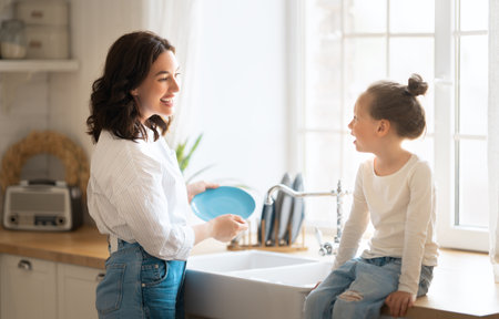 Happy day! Mom and her daughter child girl are playing, smiling in the kitchen. Family holiday and togetherness.の写真素材
