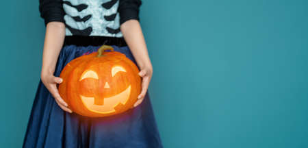 Happy Halloween! Cute little laughing girl in pirate costume on blue wall background.の写真素材