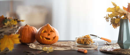Carving pumpkin on the table at home. Happy family preparing for Halloween.の写真素材