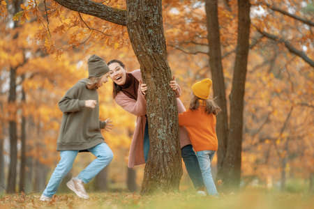Happy family on autumn walk! Mother and daughters walking in the Park and enjoying the beautiful nature.の写真素材