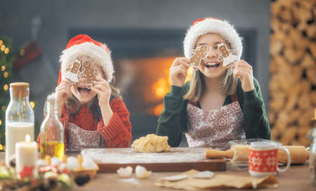 Merry Christmas and Happy Holidays. Family preparation holiday food. Sisters cooking cookies.の写真素材