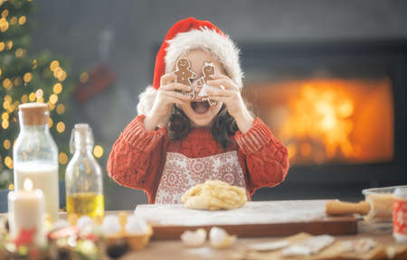 Merry Christmas and Happy Holidays. Family preparation holiday food. Girl cooking cookies.の写真素材