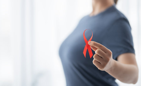 World Aids Day. Red ribbon in the hands close up