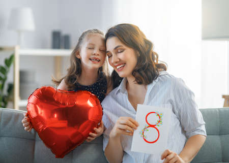 Happy loving family. Pretty young mother reading a book to her daughter.の写真素材