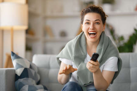 Young woman watching  TV, movies . Girl spending time at home.