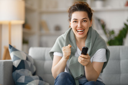 Young woman watching  TV, movies . Girl spending time at home.