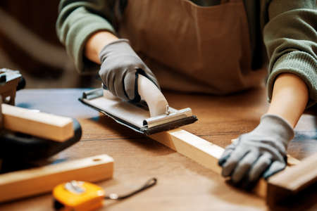 Young woman is training to be a carpenter in workshop.の写真素材