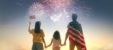Patriotic holiday. Happy family, father and daughters children girls with American flag outdoors. USA celebrate 4th of July.の写真素材