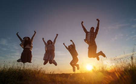 Happy family in the park. Father, mother and children are running, having fun and enjoying summer evening.の写真素材
