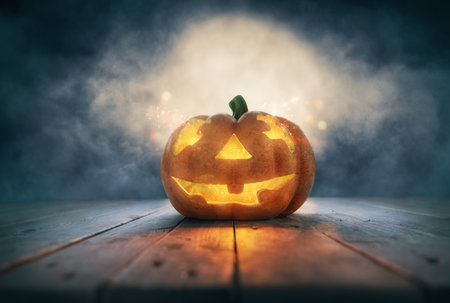 Halloween pumpkin on wood on the background of the night sky with the moon.の写真素材