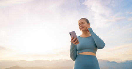 Sportive woman outdoors. Girl is training, listening music in a urban area. Concept of healthy...