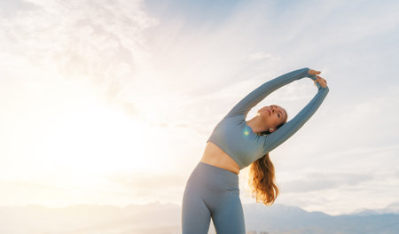 Young sportswoman is warming up, training or doing stretch exercise on rooftop of parking, garage in...