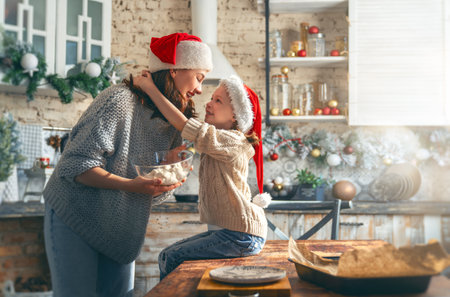 Merry Christmas and Happy Holidays. Family preparation holiday food. Mother and daughter cooking cookies.の写真素材
