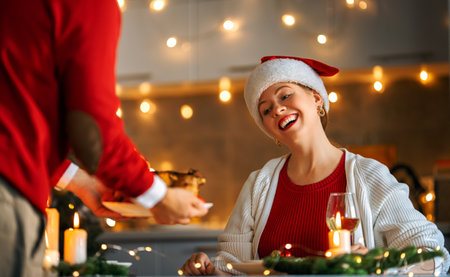 Merry Christmas. Happy loving couple is having dinner at home. Celebration holiday and togetherness near tree.の写真素材