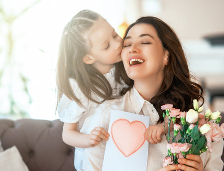 Happy mother's day. Child daughter congratulating her mother and giving her bouquet of flowers.の写真素材