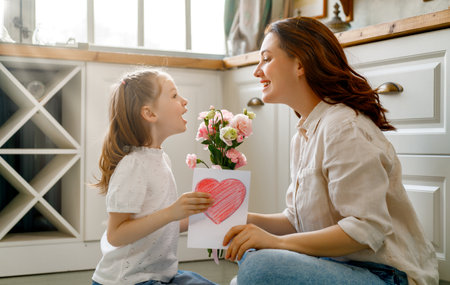 Happy mother's day. Child daughter congratulating her mother and giving her bouquet of flowers.の写真素材