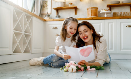 Happy mother's day. Child daughter congratulating her mother and giving her bouquet of flowers.の写真素材
