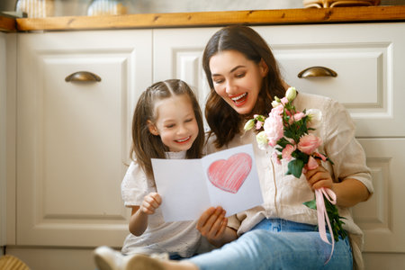 Happy mother's day. Child daughter congratulating her mother and giving her bouquet of flowers.の写真素材